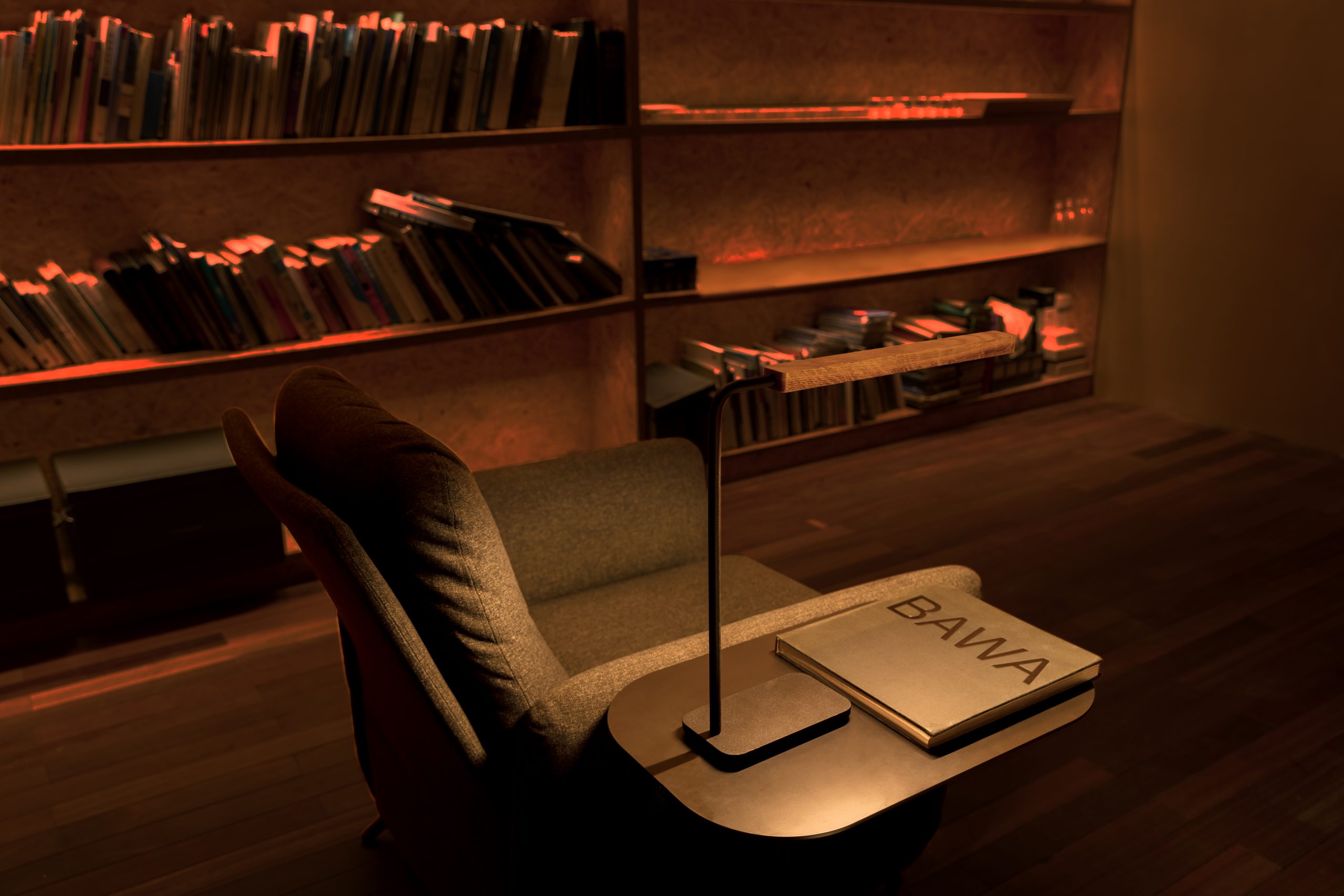 Lumatree Table Task photographed on a side table beside an armchair and a book