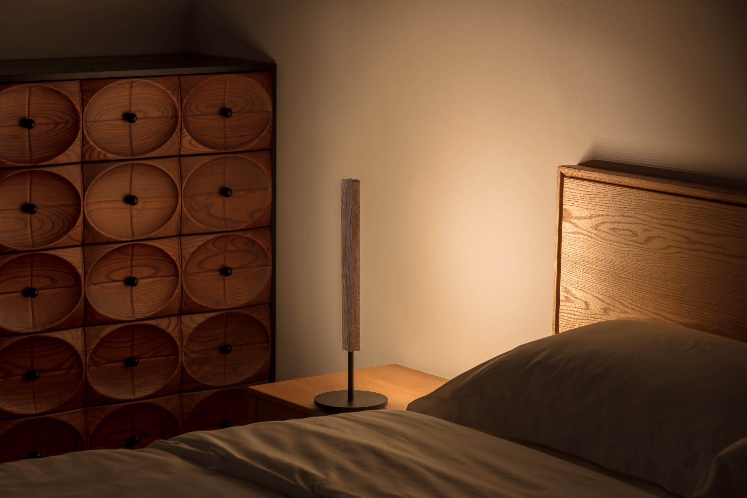 Lumatree Table Wash photographed on a bedside table directing light onto the wall